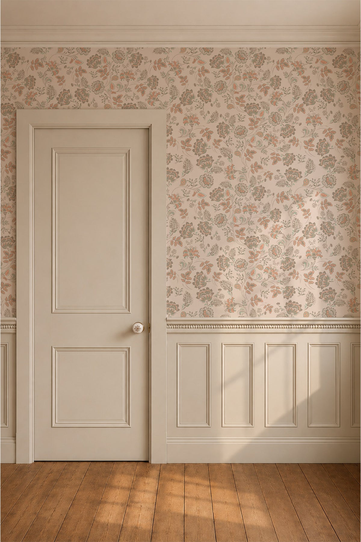 A classic interior room scene featuring a white paneled door on the left, floral wallpaper with muted orange and gray motifs on the upper wall, white wainscoting, and a warm wood floor with soft sunlight streaming in from the right.