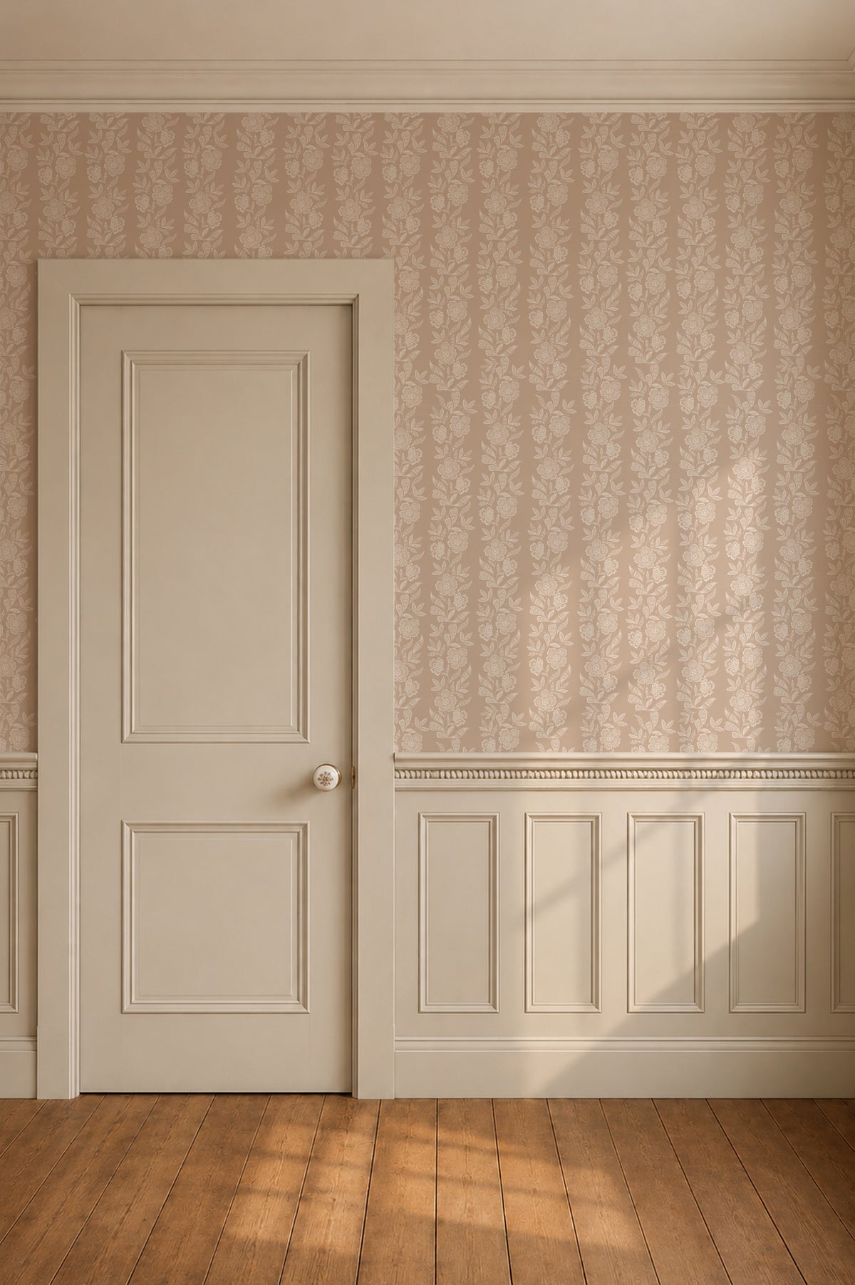 A classic white paneled interior door with a small round doorknob, set within a room featuring beige patterned wallpaper, white wainscoting, and a warm wood floor with sunlight streaming in.