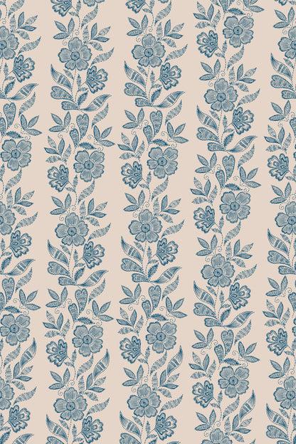 A repeating floral pattern in muted blue on a warm beige background, with vertical bands of flowers and leaves filling the frame.