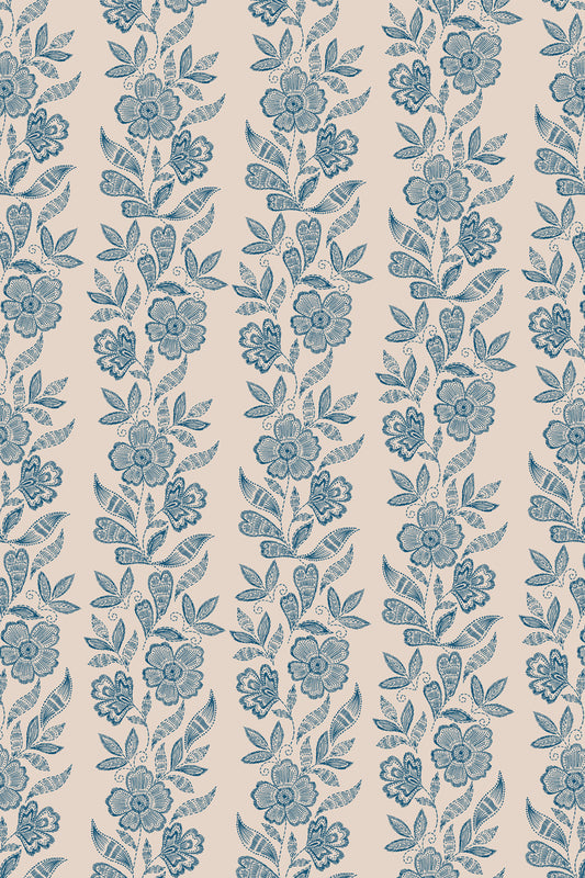 A repeating floral pattern in muted blue on a warm beige background, with vertical bands of flowers and leaves filling the frame.