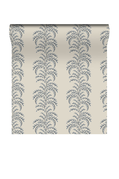 A roll of wallpaper with a repeating vertical damask-style floral pattern in muted blue-gray on a warm cream background, shown against a plain white studio backdrop.