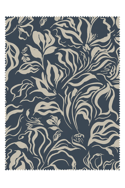 A square fabric swatch with a dark navy blue background and a beige botanical pattern of leaves and flowers, finished with a zigzag stitched border.