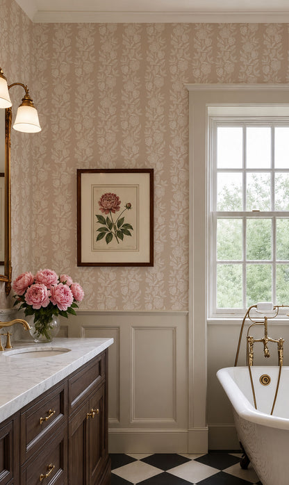 A classic vintage-style bathroom interior featuring beige floral wallpaper, white wainscoting, a dark wood vanity with gold fixtures, a white clawfoot tub with brass fittings, and a framed botanical print on the wall.