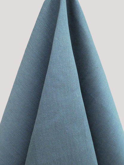 Close-up of blue fabric with a textured pattern on a light gray background