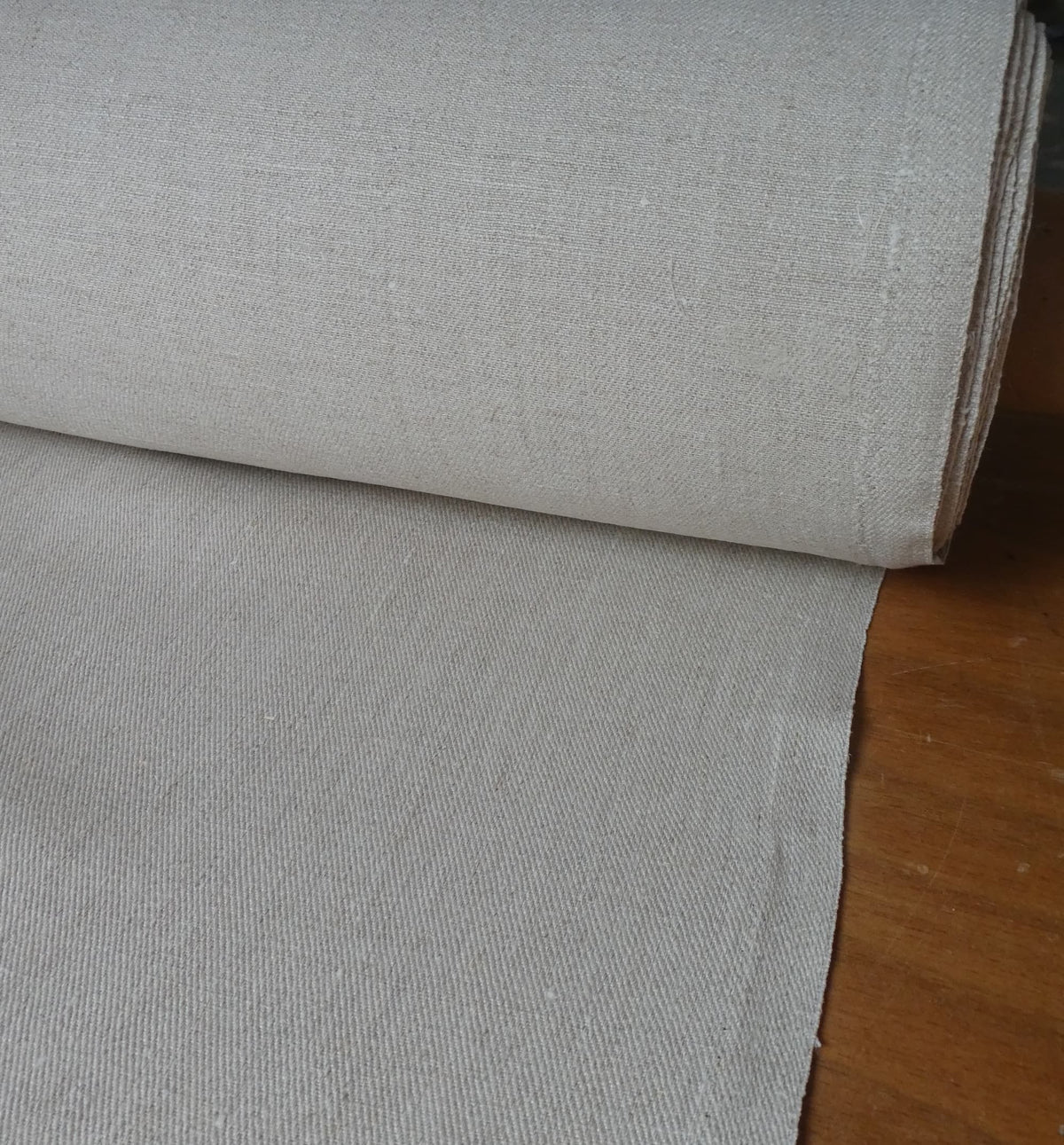 Roll of gray fabric on a wooden surface