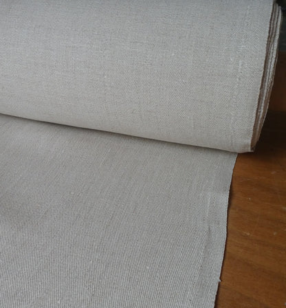 Roll of gray fabric on a wooden surface