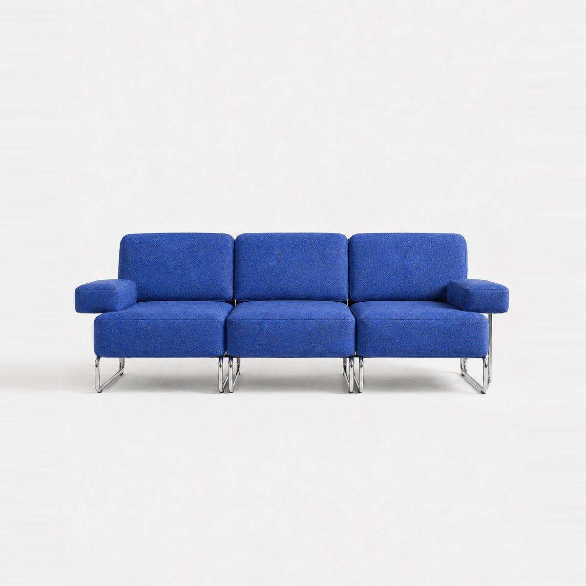 A three-seat sofa with vibrant blue textured upholstery and slim chrome legs, photographed against a seamless white studio background.
