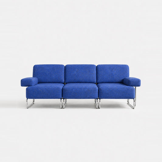A three-seat sofa with vibrant blue textured upholstery and slim chrome legs, photographed against a seamless white studio background.