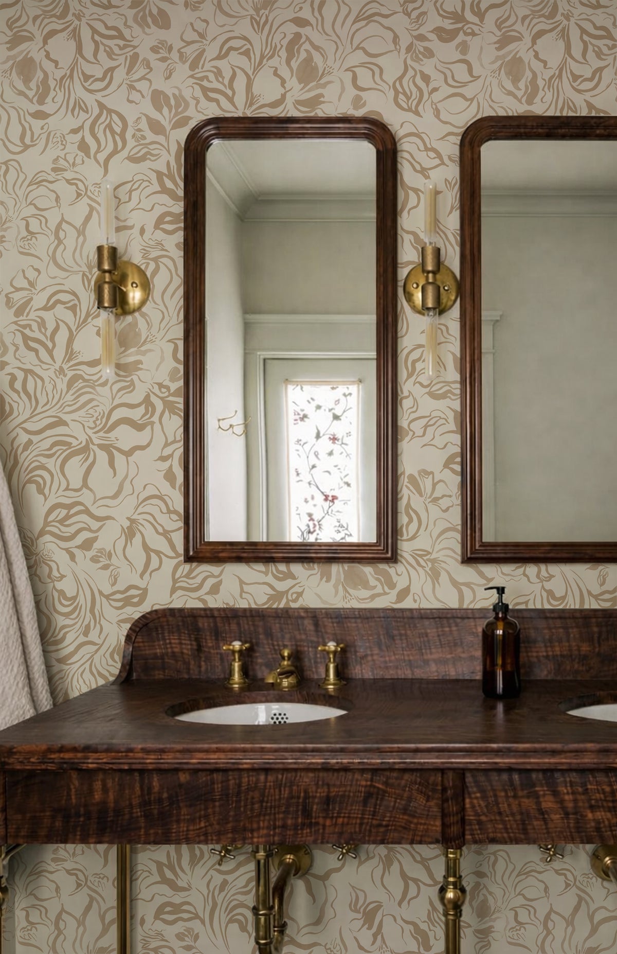 A vintage-style bathroom vanity featuring a dark wood double sink countertop with brass fixtures, two rectangular mirrors with dark wood frames, and a patterned beige wallpaper background.