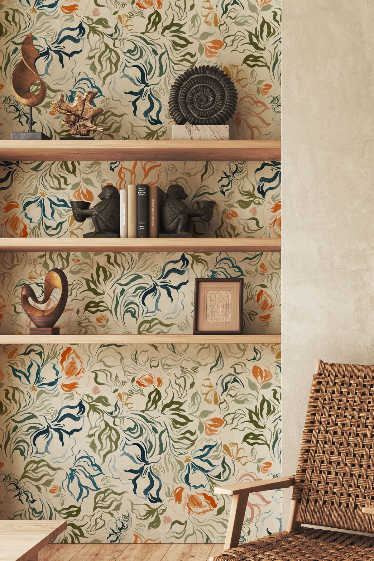 A styled interior corner showing a wall covered in a vintage-style botanical wallpaper with swirling blue, green, and orange floral motifs on a warm cream background. Built-in wooden shelves display decorative objects, and part of a woven rattan chair is visible in the foreground.
