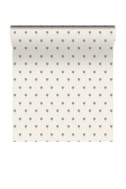 A roll of wallpaper with a repeating pattern of small blue floral motifs on a warm off-white background, shown against a plain white studio backdrop.