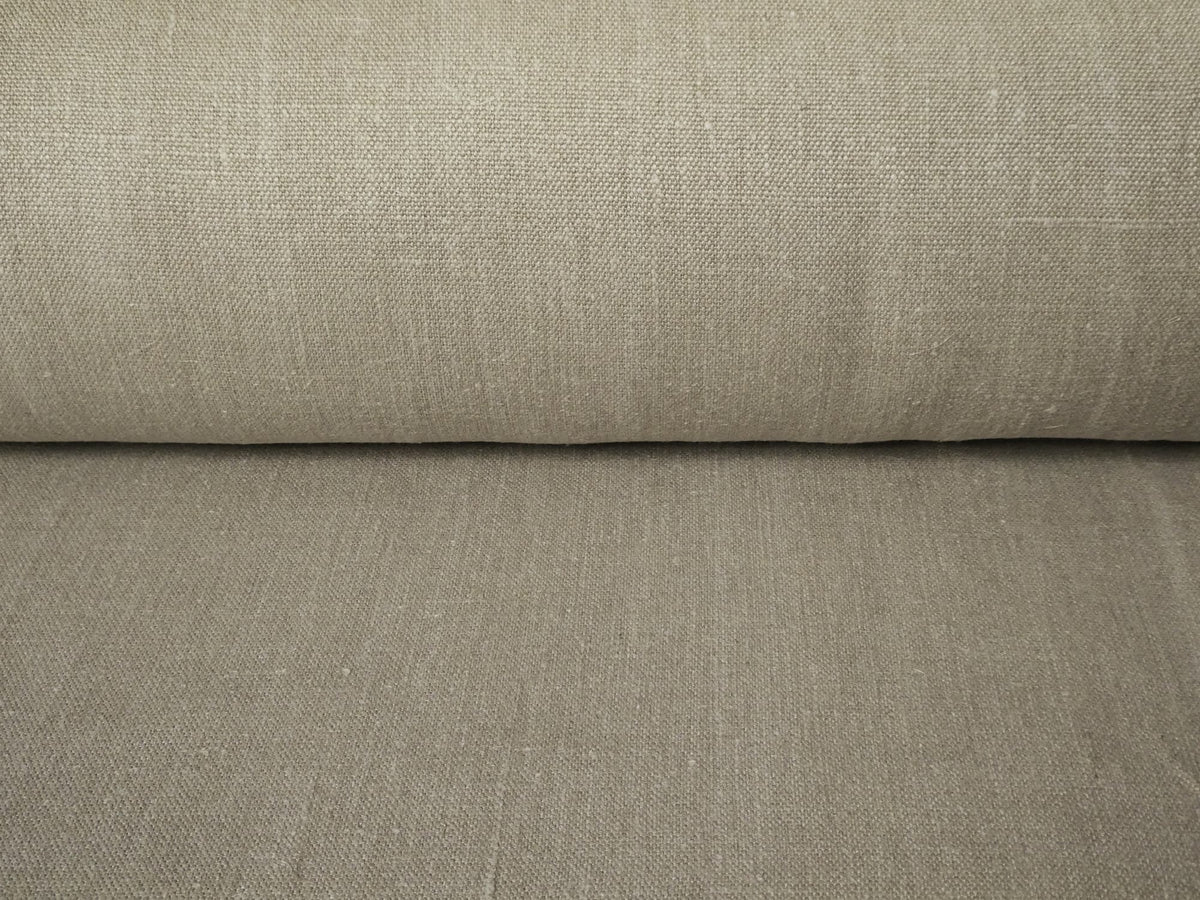 Roll of beige fabric with a subtle texture on a matching background